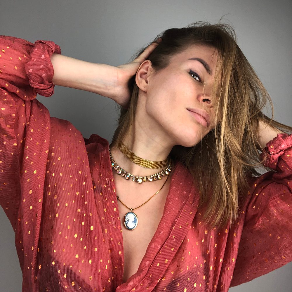 Détails d’un look sobre agrémenté de bijoux, d’un sac et d’une ceinture élégante.